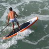 Man Riding Colorful PaddleBoard in Ocean